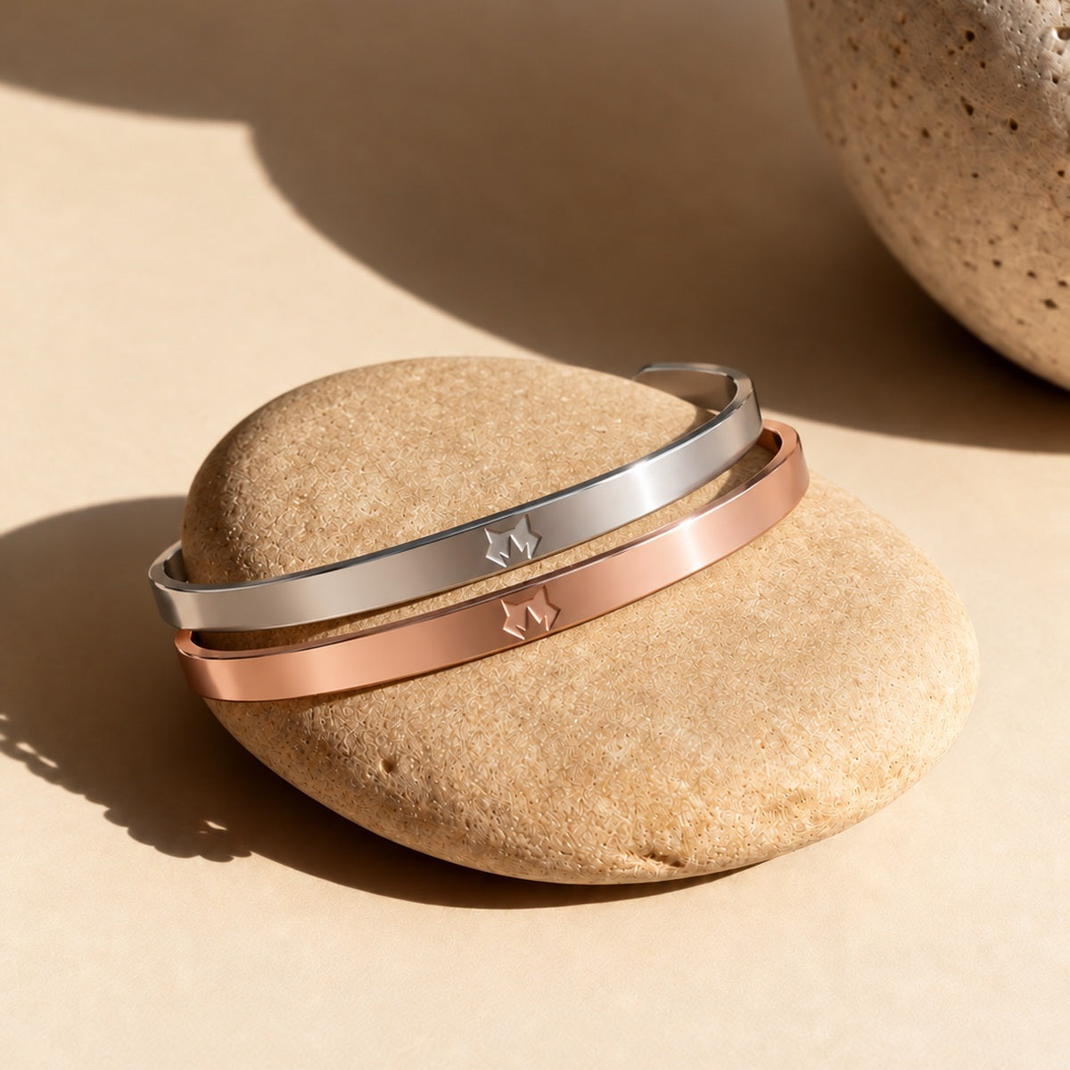 Silver and Rose Gold cuffs on sunlit stone
